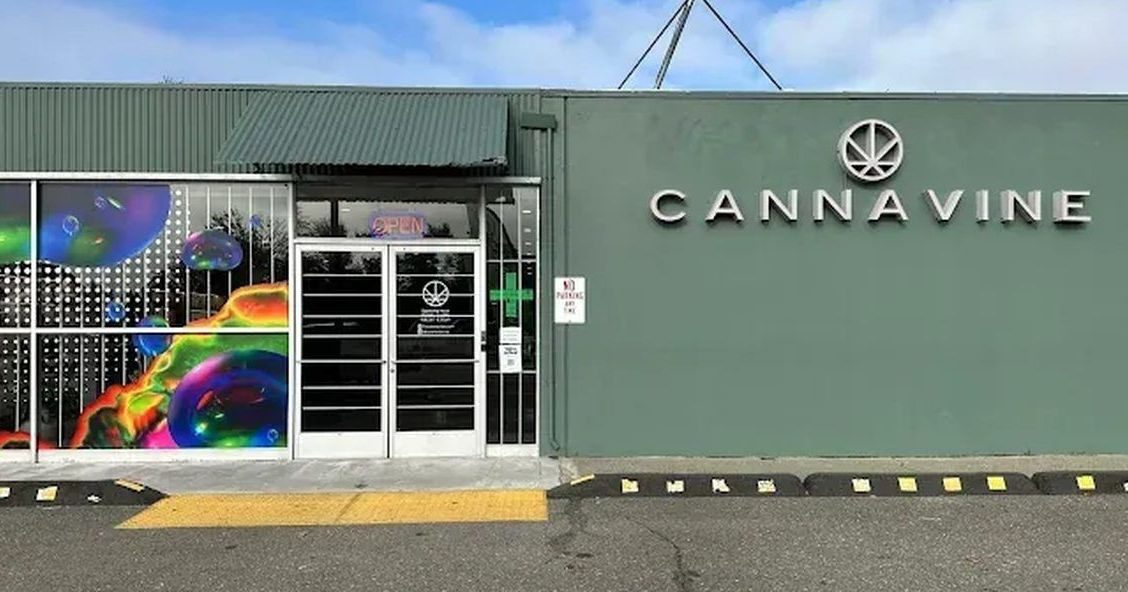 Cannavine dispensary storefront with green wall and colorful window art in Santa Rosa